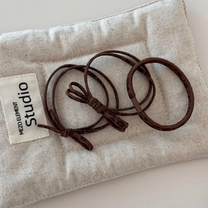 Detailed view of three-piece brown leopard print hair ties with bow and elastic texture