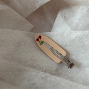 Close-up of acetic acid hair clip with red rhinestone cherry pattern and silver duckbill clip