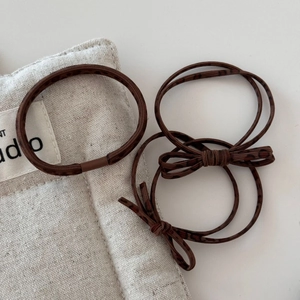 Detailed view of brown elastic hair ties and leopard print bowknot accessories