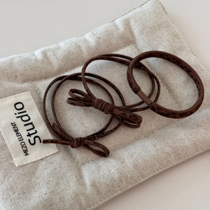 Detailed close-up of a 3-piece leopard print elastic hair tie set with a bow accent