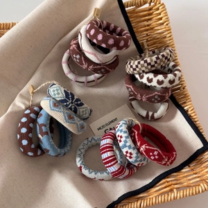 Detailed view of jacquard knitted hair ties with vintage patterns in a woven basket