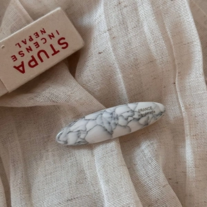 Close-up of white marble acetate oval hair clip with France Handmade silver lettering