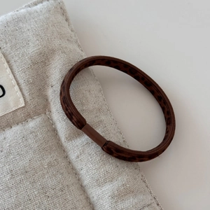 Close-up of leopard print elastic hair tie with brown spots and high elasticity material