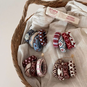 Detailed view of assorted knitted hair scrunchies with floral and striped patterns