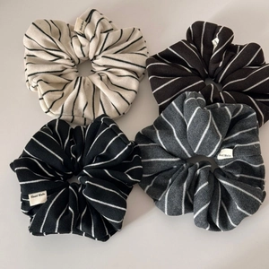 Detailed macro view of four striped knitted scrunchies with Hand Made labels