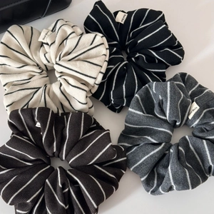 Striped scrunchie hair ties in four colors with Hand Made label and knitted texture