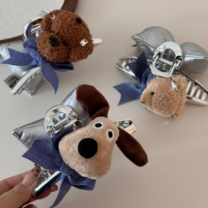 Dettaglio di fermagli per capelli in peluche a forma di cane e orso con fiocchi blu
