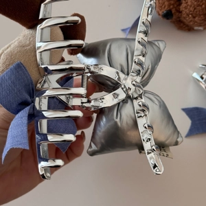 Dettaglio della molletta per capelli a fiocco in metallo argento lucido con molla forte