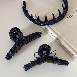 Detail of navy denim hair accessories set with woven metal chain and bow accents