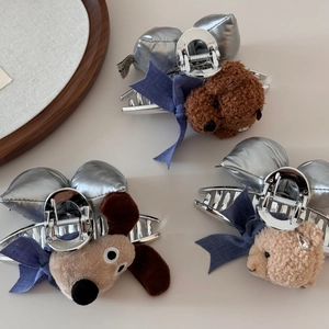 Dettaglio dei mollettoni in peluche a forma di cane e orso con fiocchi blu e argento