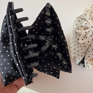 Détail des pinces à cheveux à nœud et pois en tissu noir et crème élégant