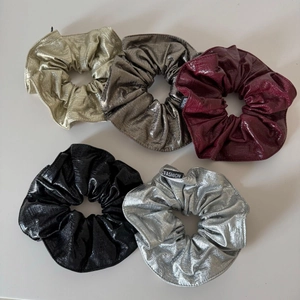 Détail de cinq chouchous en similicuir avec fini métallique et texture serpent
