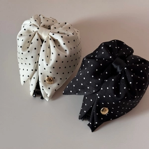Détail des pinces à cheveux en satin à pois avec accents métalliques dorés