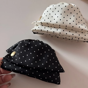 Gros plan détaillé du tissu à pois et de l'élégante plaque logo dorée sur l'accessoire