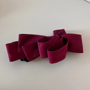 Detailed close-up of the multi-layered burgundy suede velvet bow hair clip texture