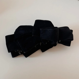 Close-up of elegant multi-layered black suede bow banana hair clip for women ponytail