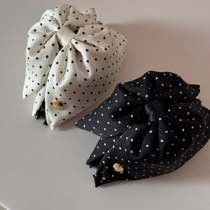 Gros plan de pinces à cheveux à pois noirs et blancs avec détails métalliques dorés