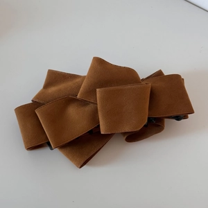 Detailed view of large multi-layer caramel suede bow hair clip with sturdy black claw grip