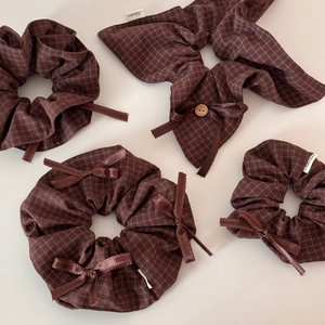 Detailed view of dark brown checkered scrunchies and bow hair tie with wood button