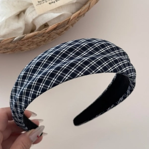 Close-up of black and white checkered fabric headband with premium non-slip lining