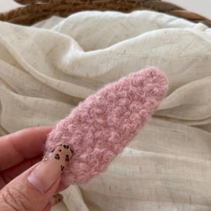 Close-up of soft pink faux shearling hair clip with a cozy curly plush texture