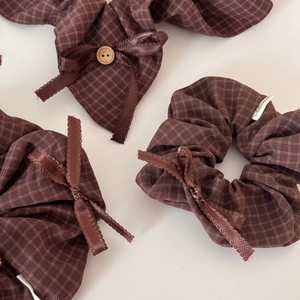 Brown plaid scrunchie with a ribbon bow and wooden button in a retro forest style