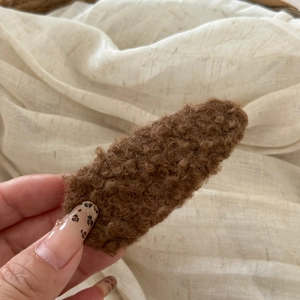 Close-up of brown plush teddy fleece hair clip showing soft texture and metal BB grip