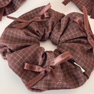 Detailed close-up of brown checkered hair scrunchie with multiple silk ribbon bows