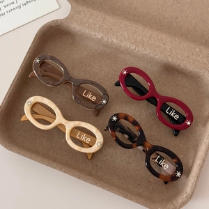 Detail view of retro acetate oval sunglasses in marble and tortoise shell patterns