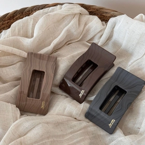 Détail de barrettes en acétate effet marbre avec lettrage doré Barrette La France