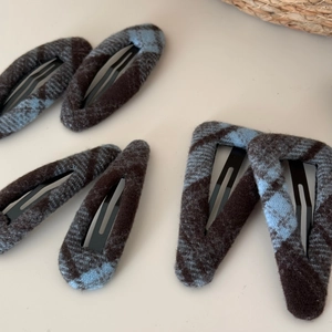 Detailed view of blue and brown plaid fabric hair clips in teardrop and triangle shapes