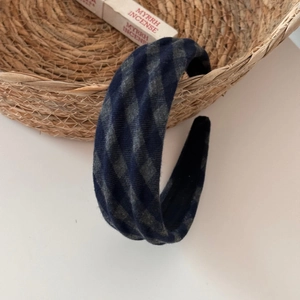 Close-up of a blue and grey plaid fabric headband featuring a textured wavy design