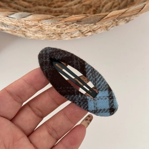 Detail of blue and brown plaid fabric hair clip with a soft woolen texture finish