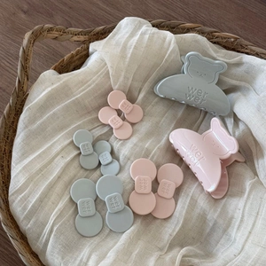 Detailansicht der bärenförmigen Haarklammern und matten Clips in Blau und Rosa