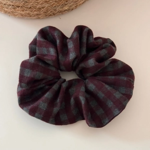 Detail of checkered plaid scrunchie in burgundy and grey with retro fabric texture