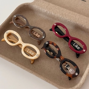 Sunglasses shaped acetate hair clips in tortoiseshell and cream colors with rhinestones