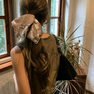 Nœud pour cheveux Harajuku en soie métallique porté sur de longs cheveux ondulés