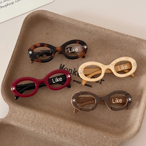 Close-up of acetic acid hair clips in oval sunglass design with rhinestone details