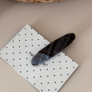 Close-up of blue and grey plaid fabric hair clip with a vintage wool texture finish