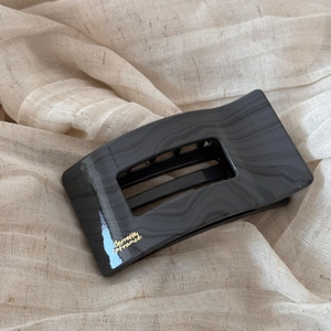 Détail de la pince à cheveux marbre gris avec texte doré Barrette la France sur tissu
