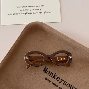 Detail of tortoise shell sunglasses with oval frames on a rustic paper pulp tray