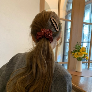 Dettaglio di un elastico a pois bordeaux e di un fermaglio per capelli con strass