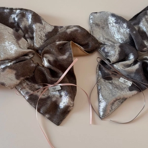 Détail de chouchous en velours métallique argenté avec rubans roses et fini brillant