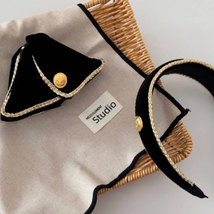 Detail of velvet headband with golden braided trim and embossed metal buckle