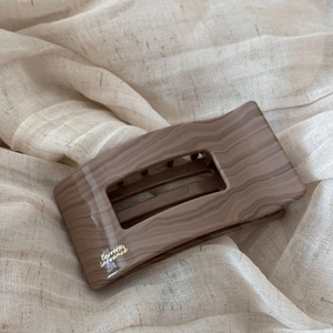 Détail d'une grande pince à cheveux motif bois avec lettrage Barrette La France doré