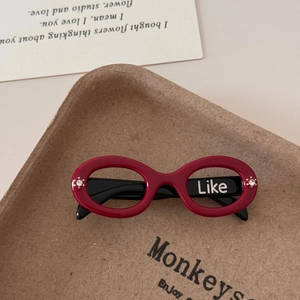 Detailed macro view of red miniature sunglasses with Like print and rhinestone accents