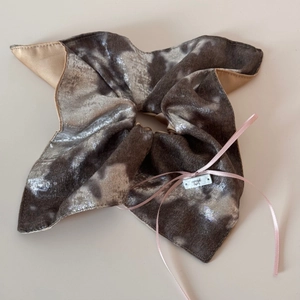 Détail d'un grand chouchou à motif marbré avec texture velours et ruban en soie rose