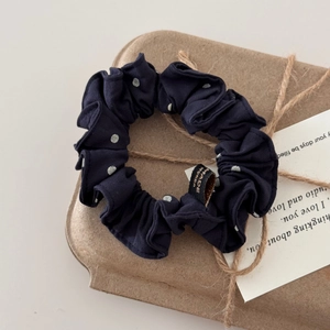 Trama dettagliata dello scrunchie blu a pois in una confezione regalo molto elegante