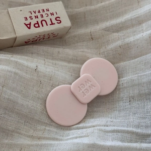 Detail der rosa matten Essigsäure-Haarklammer mit minimalistischer Schleife und Gravur