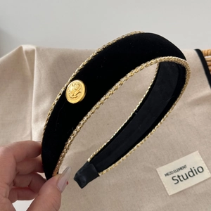 Detail of black velvet headband with gold braided trim and vintage embossed buckle